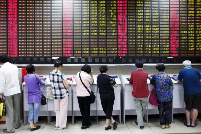 Investors look at computer screens showing stock information at a brokerage house in Shanghai, China, July 8, 2015. Chinese stocks dived on Wednesday after the securities regulator said the tumbling stock market in the world's second-biggest economy was in the grip of "panic sentiment" as investors ignored a battery of support measures from Beijing. REUTERS/Aly Song